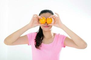 beautiful young south east Asian Chinese woman holding oranges on eye on white background photo