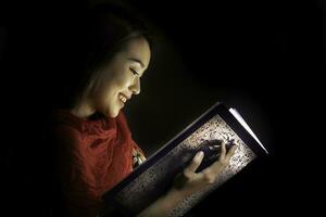 Asian woman opening mystic book box magical light dark background photo