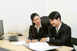 Young Asian male female wearing suit sitting at office desk thinking meeting disucsing sign document agreement photo