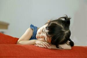 Little girl child sleeping over sofa edge photo