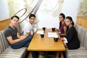 group of Asian young man woman friend student colleagues talk mingle study discuss coffee shop look at camera photo