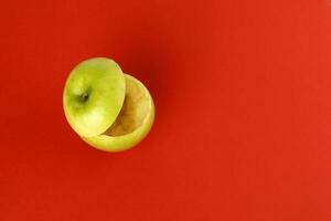 Healthy Green Cut Apple floating top slice juice drink idea concept on red background photo