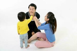 South East Asian Chinese couple husband wife son child play sit on floor eat treat white background love photo