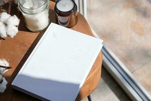 Magazine and book mockup design. Blank magazine on modern wooden table with candles , shadow overlay photo