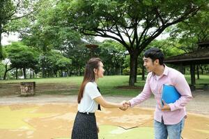 young asian malay chinese man woman outdoor park walk stand study talk discuss laptop file book backpack pose meet handshake photo