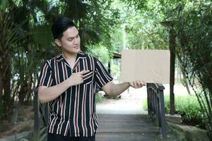 Young Asian Malay man woman outdoor green park walk talk discuss mingle photo