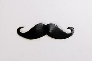 Black moustache shape paper die cut selfie portrait party fun paper prop sticker stick on white background photo