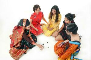 South east Asian Malay Chinese Indian race ethnic origin woman wearing dress costume baju kurung cheongsam samfu kebaya Sharee multiracial community playing Batik Batu Seremban on white background photo