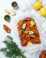 top view of cooked crawfish platter with lemons and spices photo