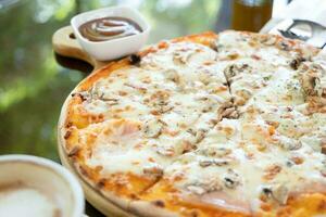 italian chicken pizza with mozarella cheese on glass table in street cafe photo