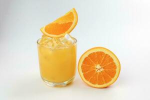 Fresh yellow orange juice in glass with orange slice and ice cube on white background photo