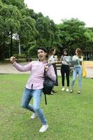 Young asian malay chinese man woman outdoor park walk stand study talk discuss point laptop file book backpack joy victory photo