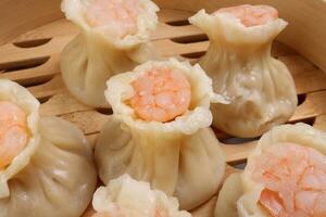 Prawn shrimp shaomai dim sum dumpling in bamboo steamer on white background photo