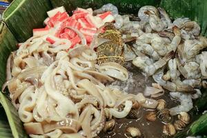 Ready to cook raw fish shrimp cuttlefish cockle crab in banana leaf  on cold ice photo