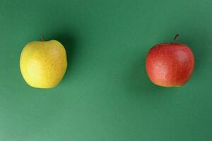 Red yellow green apple on green colour background photo