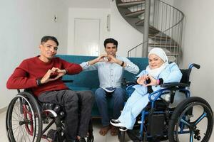 Portrait of young man and woman talking discussing work business. Two on wheelchair are paralyzed and one sitting on sofa adhd also Autism autistic love hart photo