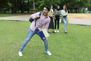 joven asiático malayo chino hombre mujer al aire libre parque libro archivo carpeta ordenador portátil computadora teléfono sentar estar estudiar mezclarse foto