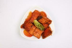 Pan friend salmon fish fillet in white triangular plate on white background photo