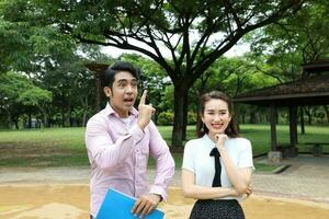 young asian malay chinese man woman outdoor park walk stand study talk discuss laptop file book backpack pose happy mingle idea photo