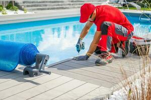 Professional Outdoor Swimming Pools Worker Finishing Composite Deck Installation photo