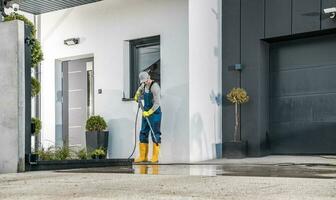 Men Cleaning His House Surrounding Using Pressure Washing Machine photo