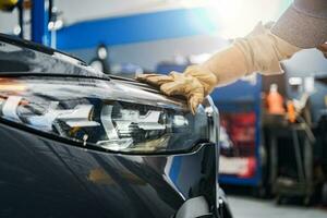 Auto Service Technician Checking on a Car Headlight photo