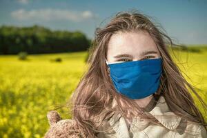 Happy Teenager Caucasian Girl Wearing Blue Face Mask photo