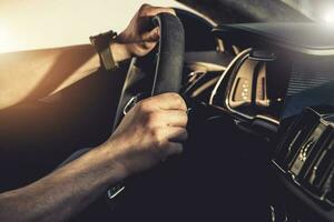 Caucasian Driver Behind Exotic Car Steering Wheel photo