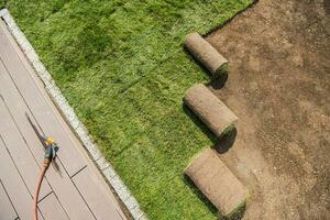 Rolls of Newly Installed Grass Turfs Next to Pool Deck photo