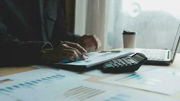 Close up businessman hand using calculator and working with laptop calculate about finance accounting at coffeeshop outdor.finance accounting concept video