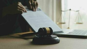 Justice and law concept.Male judge in a courtroom with the gavel, working with, computer and docking keyboard, eyeglasses, on table in morning light video