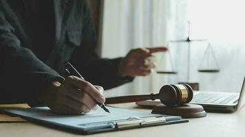 Justice and law concept.Male judge in a courtroom with the gavel, working with, computer and docking keyboard, eyeglasses, on table in morning light video