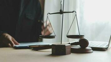 Justice and law concept.Male judge in a courtroom with the gavel, working with, computer and docking keyboard, eyeglasses, on table in morning light video