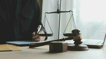 Justice and law concept.Male judge in a courtroom with the gavel, working with, computer and docking keyboard, eyeglasses, on table in morning light video