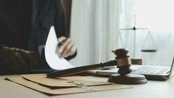 Justice and law concept.Male judge in a courtroom with the gavel, working with, computer and docking keyboard, eyeglasses, on table in morning light video