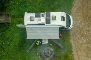 RV Park Pitch with Camper Van and Campfire Place Aerial View photo