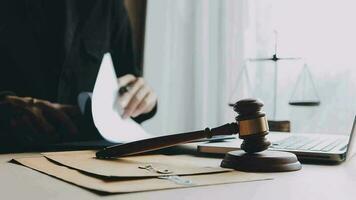 Justice and law concept.Male judge in a courtroom with the gavel, working with, computer and docking keyboard, eyeglasses, on table in morning light video