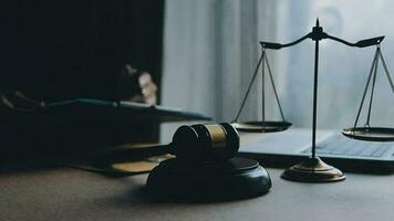 Justice and law concept.Male judge in a courtroom with the gavel, working with, computer and docking keyboard, eyeglasses, on table in morning light video