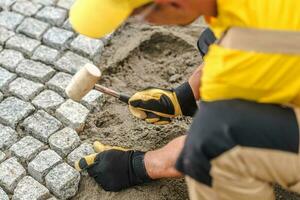 Professional Construction Worker Laying Pavers photo