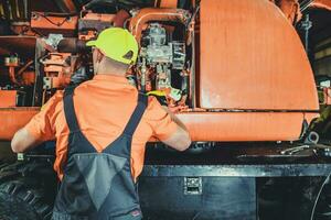 Excavator Mechanic Taking Closer Look Into the Machine Diesel Engine photo