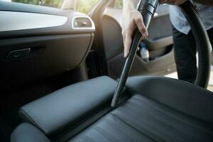 Man Using Car Vacuum Cleaner To Tidy Car. photo