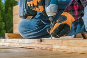 Carpenter Using Drill Driver In Woodworking. photo