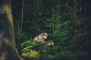 ocultación cazador furtivo en profundo bosque foto