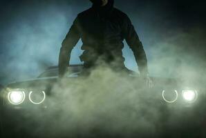 Illegal Street Racer in Front of His Muscle Car photo