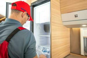 Recreational Vehicle RV Technician Replacing Travel Trailer Refrigerator photo