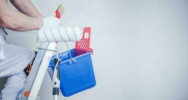 Room Painter on a Ladder and His Tools photo