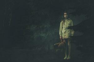 Lost Emotionless Girl with Teddy Bear in the Middle of Dark Night Forest photo