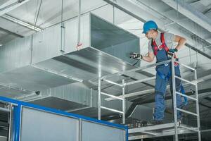 HVAC Technician Testing Newly Installed Warehouse Ventilation System photo