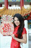 Young south east asian Chinese man woman traditional costume Chinese new year greeting outdoors at temple photo