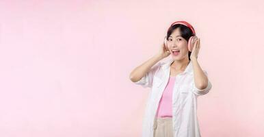 Smile pretty model person listen music song and enjoy dance with wireless headphone online audio radio sound. Positive fun exited joyful youth female woman sing on pink isolated background studio photo